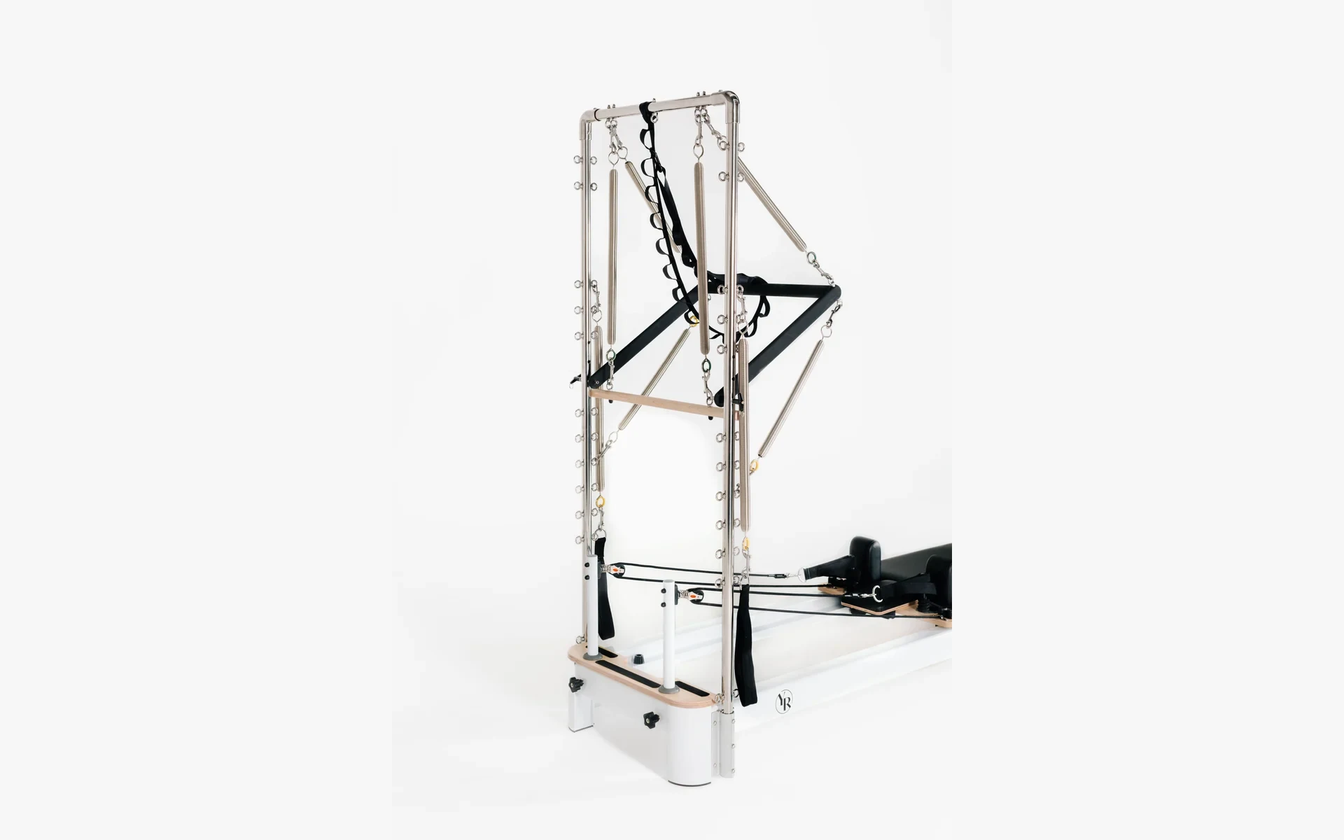 Reformer with a half trapeze tower, springs, and straps